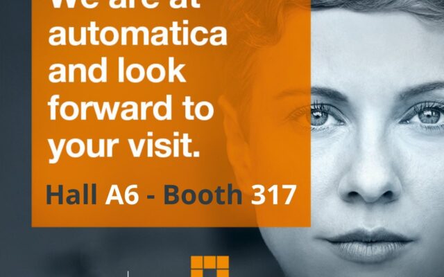 There's the face of a woman in black and white of the back. On the front there are the logos of Samac and Automatica and the phrase "We are at automatica and look forward to your visit. Hall A6 - Booth 317"; the phrase is written on an orange square.